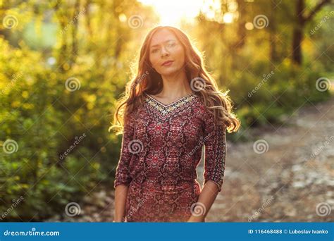 Young Woman Wearing Dress In Forest Backlight By Sunset Light Stock