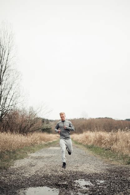 Atleta Masculino Corriendo En El Camino De Tierra Foto Gratis