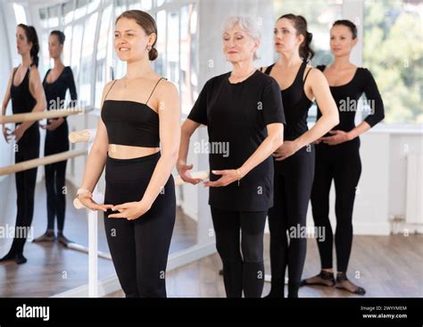 Girls In Ballet Class Perform First Position With Participation Of Mature Female Mentor Stock