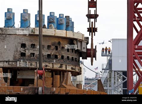 Workers Look On From A Platform As A Massive Crane Lifts A Ton