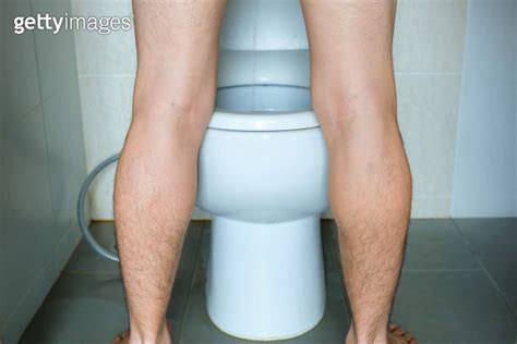 Man Peeing To Toilet Bowl In Restroom From Back Health Concept