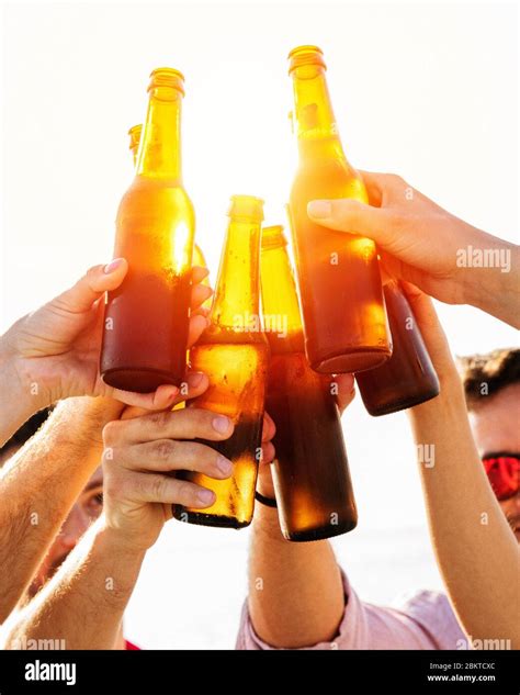 Cheers Group Of Happy People Are Toasting With Beer Bottles During