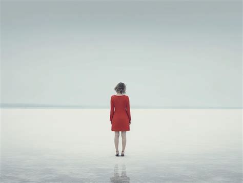 Una Mujer Con Un Vestido Rojo Se Para En El Agua Frente A Un Cuerpo De