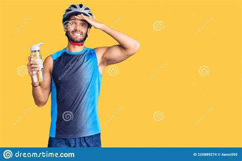 Handsome Hispanic Man Wearing Bike Helmet And Holding Water Bottle