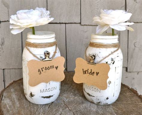 Two Mason Jars With White Flowers In Them