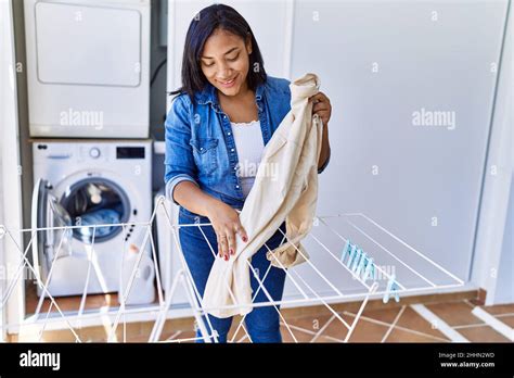 Hispanic Brunette Woman Hanging Clean Laundry On Rack At Laundry Room Stock Photo Alamy
