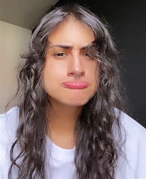 A Woman With Long Gray Hair Is Making A Funny Face