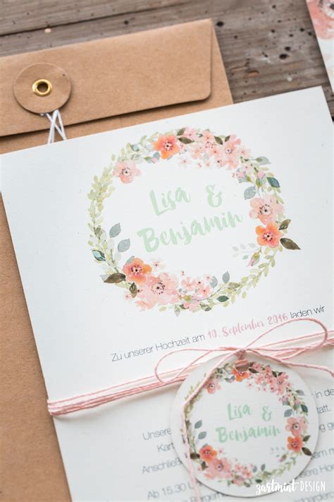 Hochzeitseinladungen mit Blumenkranz auf Naturpapier mit süßen Anhängern