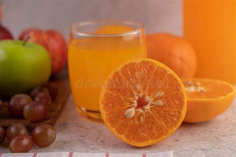 Naranja Cortada Por La Mitad Con Uvas Y Zumo De Naranja Foto De Archivo