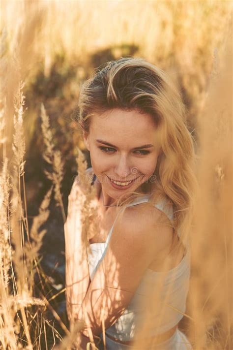 Beautiful Blonde Woman On A Walk In A Field With Dry Grass A Walk In