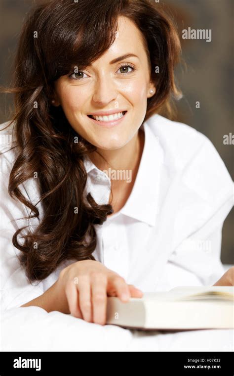 Woman reading book in bed Stock Photo - Alamy