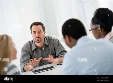 Office Interior A Group Of Four People Two Men And Two Women Seated