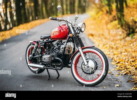 Red Custom Old Fashioned Motorcycle On The Road In The Forest With