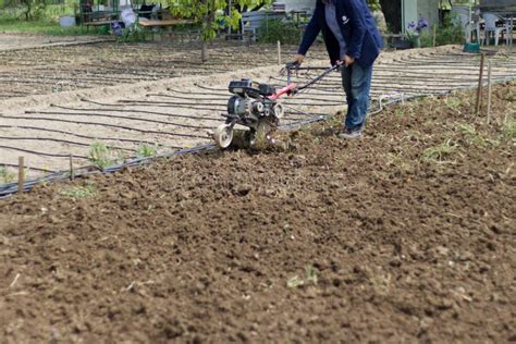 A Farmer Plows The Land With A Hand Held Motor Plow Agricultural