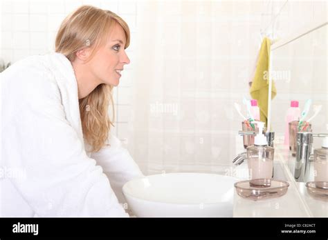 Woman Looking Into Bathroom Mirror Stock Photo Alamy