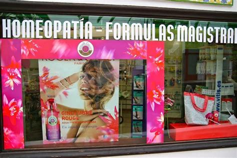 A Store Front Window With Pink Flowers In The Window And A Woman S Face