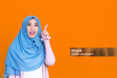 Happy Muslim Woman In Hijab Pointing At Something Isolated On Color