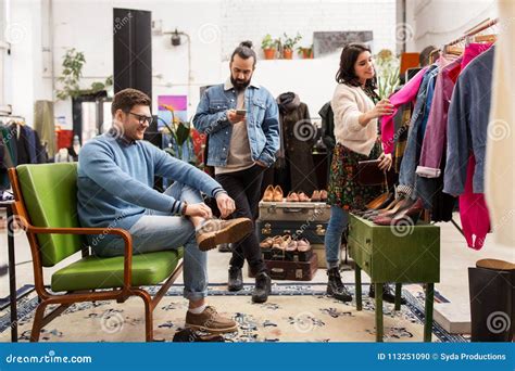 Amigos Que Eligen La Ropa En La Tienda De Ropa Vintage Foto de archivo ...