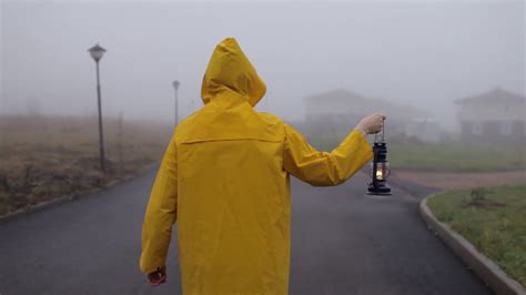 Man In Yellow Raincoat With Kerosene Lamp Stock Footage Sbv