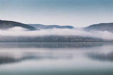 Lago de montanha nuvens na manhã nevoenta paisagem de outono Foto