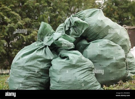 Pile of green plastic free ecological trash bags on dump outdoors ...