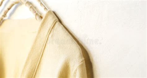 A Sweater In White Hanging On Clothes Hanger On White Background Stock