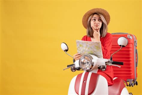 Vue De Face De La Jeune Femme Confuse Sur Un Cyclomoteur Avec Valise