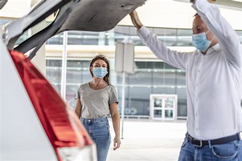 A Taxiuber Driver Helping A Passenger With Her Luggage At The Airport