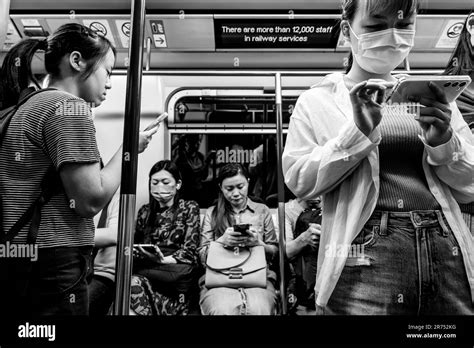 People Using Their Smartphones On A Mtr Train Hong Kong China Stock