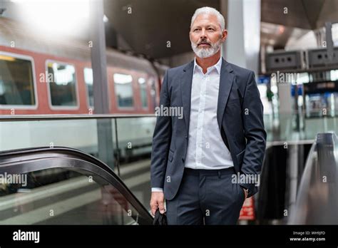 Mature Businessman On An Escalator At The Train Station Stock Photo Alamy