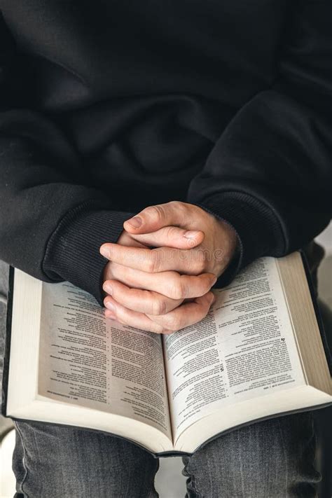 Bíblia Do Livro Aberto Em Mãos Masculinas Fechadas Foto de Stock