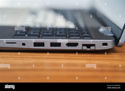 Side view of a gray laptop keyboard on a wooden table. USB ports on a laptop Stock Photo - Alamy