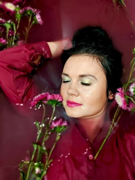 Fashion Interior Photo Of Beautiful Woman With Dark Hair Lying Naked In Petals Of Chrysanthemum