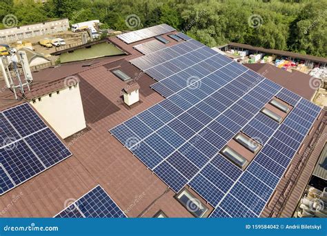 Aerial View Of Many Solar Panels Mounted Of Industrial Building Roof