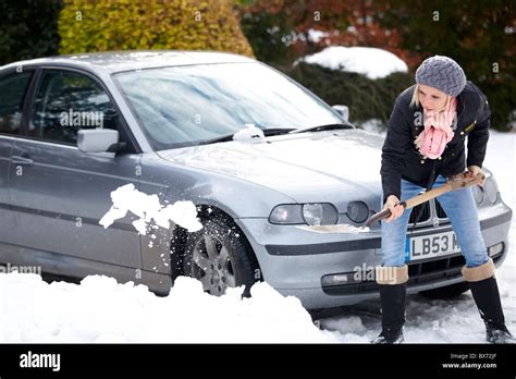 Woman Digging Out Car From Snow Stock Photo Alamy