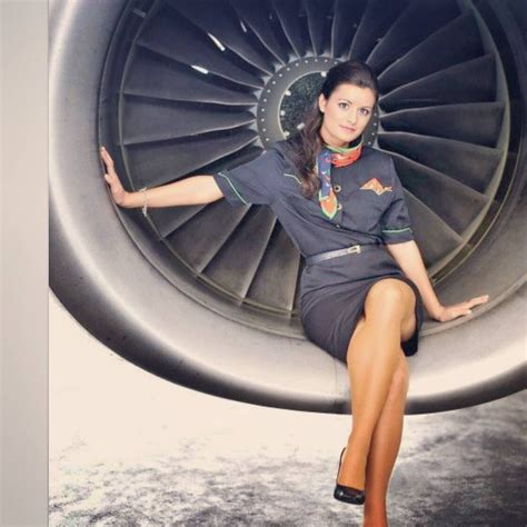 A Woman Sitting On The Ground In Front Of An Air Plane S Jet Engine