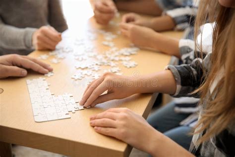 Group Of People Assembling Puzzle On Wooden Table Stock Image Image