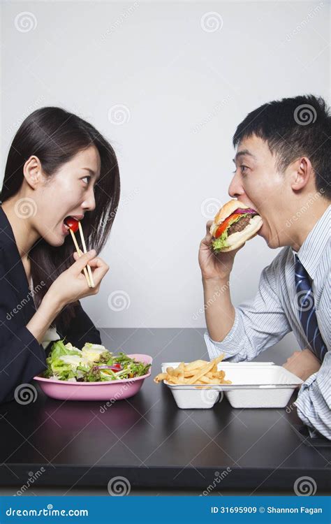 Two Young Business People Eating A Meal Royalty Free Stock Images