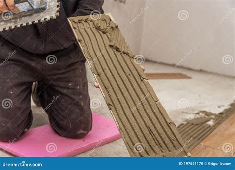 Worker Placing Ceramic Floor Tiles On Adhesive Surface Stock Photo