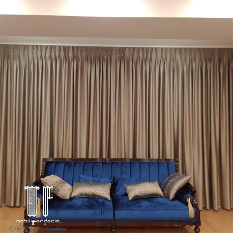 A Blue Couch Sitting In Front Of A Window With Curtains On The Wall