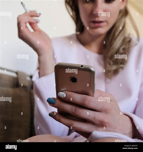 Woman Smoking Cigarette Holding Mobile Phone Stock Photo Alamy