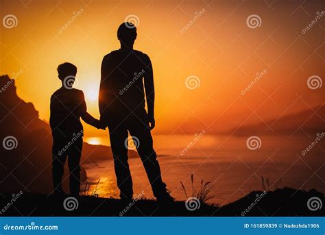 Silhouette Of Father And Son Holding Hands In Sunset Nature Stock Image