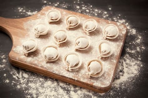 Premium Photo Semifinished Pelmeni Dumplings On The Wooden Board