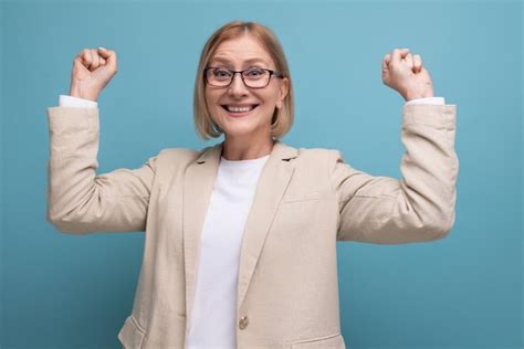 Premium Photo Happy S Mature Woman In A Stylish Jacket Won A Victory On A Plain Background