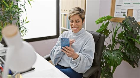 A Smiling Hispanic Woman With Short Blonde Hair Enjoys Using Her