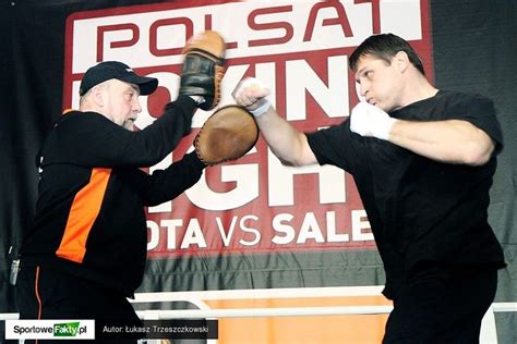 Two Men In Black Shirts And Orange Pants Are Fighting With Each Other