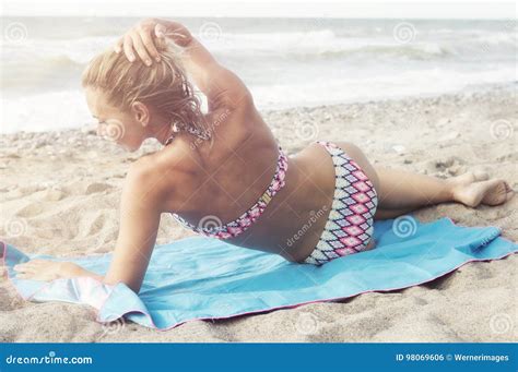 Mujer Rubia Hermosa En El Bikini Que Miente En La Playa Foto De Archivo