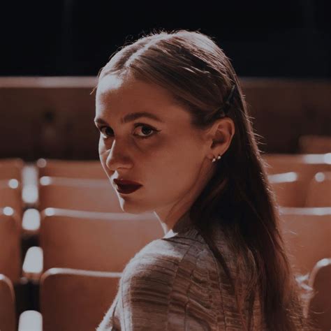 A Woman With Long Hair Sitting In Front Of An Empty Theater Seat