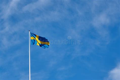 Bandera De Suecia Contra Un Cielo Nublado Azul Imagen De Archivo