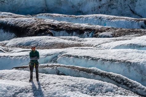 Cimber Do Gelo Na Frente De Uma Caverna De Gelo Que Conduz De Uma Canoa